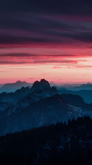 Obraz premium A vibrant red and pink sunset casts a warm glow over majestic mountains, creating a serene and picturesque landscape.