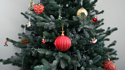 Christmas tree decorated close-up  with traditional ornaments slide back. Large red ball ornament...