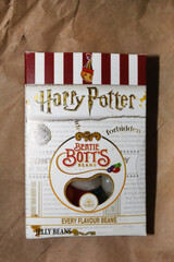 Fototapeta premium Kyiv, Ukraine. 10.10.2024:Bertie Botts Every Flavor Beans box displayed on brown packaging in a warm setting. Stock editorial photo.