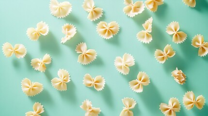 Obraz premium Farfalle pasta scattered randomly on a pastel mint green background, with playful composition.