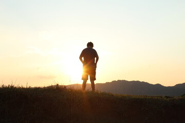 silhueta de homem com montanhas ao fundo no por do sol em tirandentes, minas gerais 