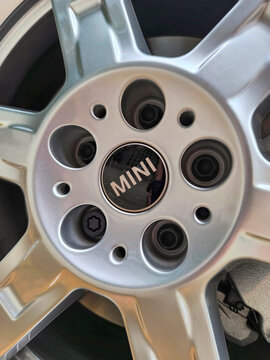 Mini logo located on the steering wheel, tires or bodywork of a Green Countryman on a street in the city of Madrid