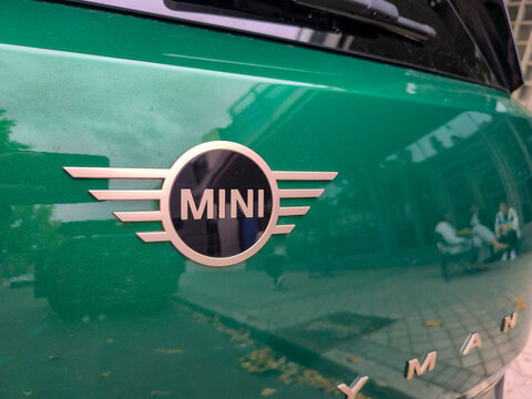 Mini logo located on the steering wheel, tires or bodywork of a Green Countryman on a street in the city of Madrid