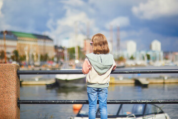 Adorable happy preschooler girl enjoying summer day on a street of Helsinki, Finland .