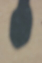 A vague view of a concrete sidewalk with a shadow.