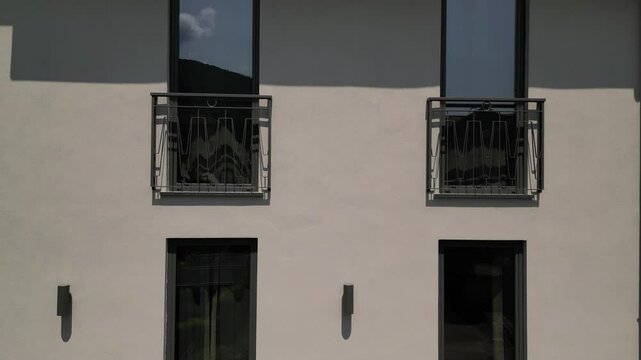 Drone video showing grey stone modern hotel with balconies with ret tiled Italian roof in an Italian village, destination tourism 