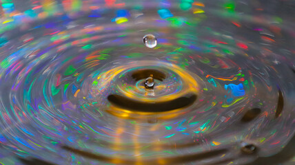 A stunning indoor shot captures a water droplet, its surface reflecting intricate patterns and...