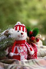 Winter postcard. Teddy bear on the background of a fir branch. Christmas and New Year mood.