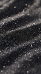 Close-up of sparkling black sand with fine details and shimmering highlights