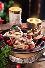 Star shaped canapes with herring fillets and cranberries on Christmas table in rustic style