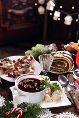 Traditional Polish Christmas Eve supper with red borsch and dumplings on festive table