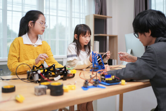 children working on circuit boards of small robot at technology and engineering workshop,elementary children learning STEM Education in school class,
