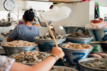 Woman selling fresh seafood at a market in El Salvador
