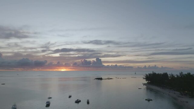 Aerial footage of tropical sunset on an siland withj ocean and boats. Mauritius