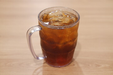 Ice tea in glass on wooden table. Selective focus and shallow depth of field.