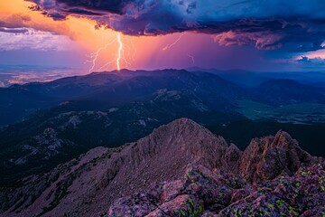 Lightning strikes over a mountain range at sunset.