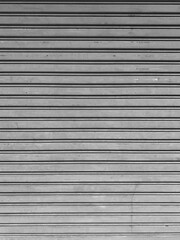 Old white metal roller shutters door. Line pattern texture aluminum doors background. Old gray metal background texture.
