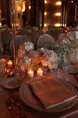 Modern luxury destination wedding decor in dark gold mode in historical Italian villa Arvedi with candelabras, gold chairs flowers and artworks