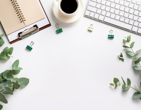 top view office table desk workspace frame with green leaves eucalyptus clipboard keyboard computer and coffee cup isolated on white background flay lay ideas notes or plan writing concept