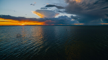 Cloudy contrast sunset. View from the coast towards sea. Italy.