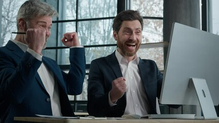 Caucasian happy successful men businessmen business partners looking at computer screen in office celebrate investment deal financial achievement goal celebrating victory rejoice success sales growth