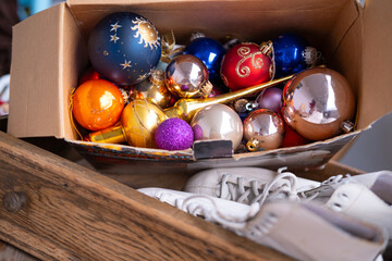 vintage wooden drawer with white ice skates and cardboard box filled with nostalgic colorful...