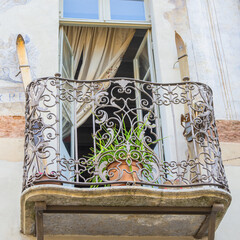 Antique balcony in Cuneo, Italy, with wrought-iron railing with ornaments