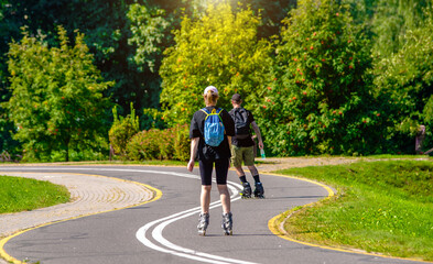 Naklejka premium A girl and a man on roller skates rides on the track 