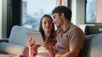 Married couple looking tablet sitting sofa cozy home closeup. Smiling man  - Powered by Adobe