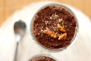 Two bowls of chia seed, chocolate and orange pudding. Healthy snack, wooden background. Top view.