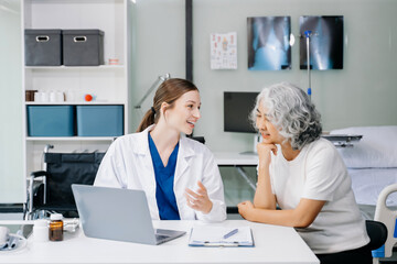 Fototapeta premium Portrait of female doctor explaining diagnosis to her patient. Doctor Meeting With Patient In Exam Room. A medical practitioner reassuring a patient .