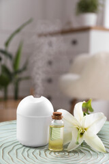 Essential oil diffuser, cosmetic product and lily flower on table at home