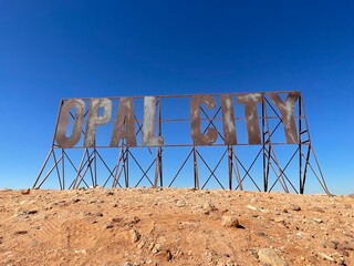 Large metal sign saying Opal City at opal mining underground town of Coober Pedy, South Australia