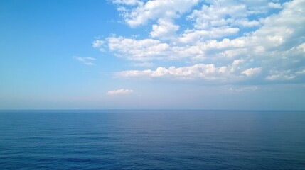 Obraz premium The vast European sea stretches to the horizon, with a cloud-dappled sky perfect for text or branding. No one in sight