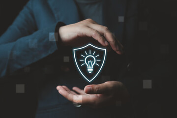 A businessman’s hand reveals a virtual screen displaying the protection of intellectual property...