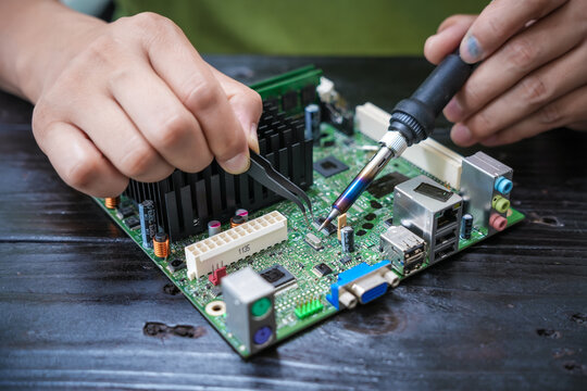 Engineer, a precise computer motherboard repair technician, uses a screwdriver to change parts, focuses on technology maintenance, repairs electronic devices, and supports ideas. - Powered by Adobe