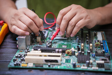 Engineer, a precise computer motherboard repair technician, uses a screwdriver to change parts,...