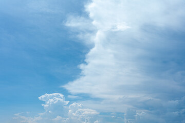 Fluffy white clouds drift across a clear blue sky, painting a beautiful landscape of nature's wonder