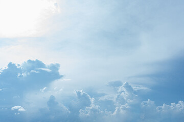 Fluffy white clouds drift across a clear blue sky, casting soft shadows on the Earth