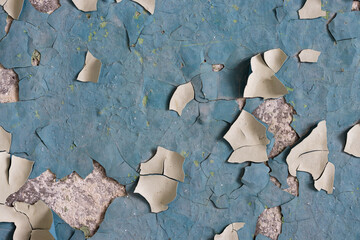 Peeling paint on the wall. Old concrete wall with cracked flaking paint. Weathered rough painted...