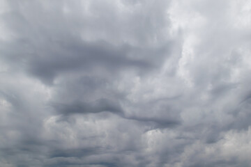Obraz premium Gray rain clouds loaded with rain in the sky. Beautiful dark dramatic sky with storm clouds before rain or snow. Thunderstorm sky landscape.