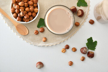 Hazelnut drink on tablecloth on a white bench with nuts