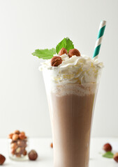 Detail of milkshake with hazelnuts and cream decorated with nuts