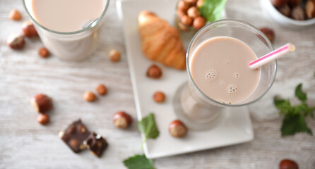 Detail of refreshing hazelnut drinks in glass cups on table