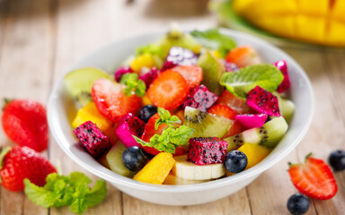 healthy colorful fruits salad with mango, pitaya, blueberry and kiwi