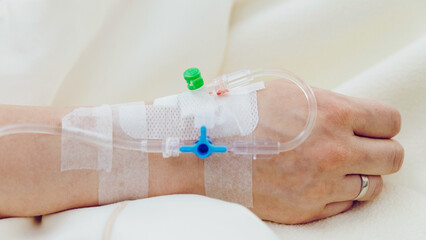 Person's Hand with Drip Infusion on Bed