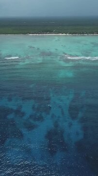 Vertical Aerial VIew of the caribbean sea, boat cora, reef and Tankah Bay in Tulum, Mexican Caribbean