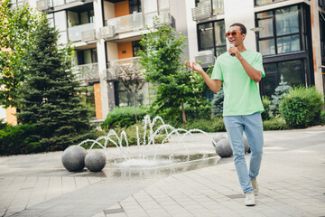 Full size photo of nice young man journalist wear t-shirt speak microphone walk downtown street...