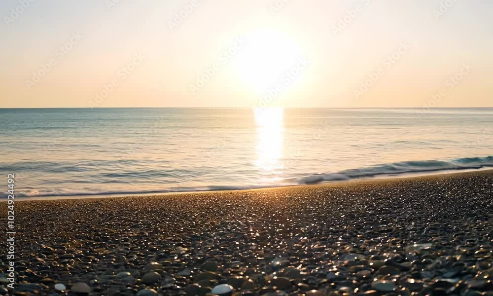Poster a close up of a pebbled beach with the sun setting over the ocean in the background