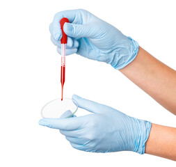 Hand in medical gloves holding a pipette with blood and a glass on an empty background. Laboratory analysis, medical testing, healthcare research.